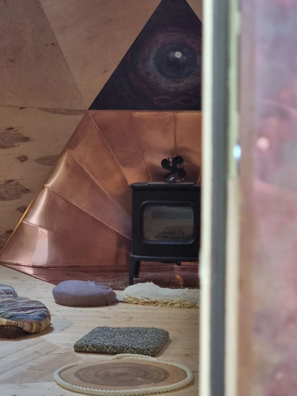 Kuppeltempli soe siseruum: kamin, puidust geomeetria ja istumispadjad